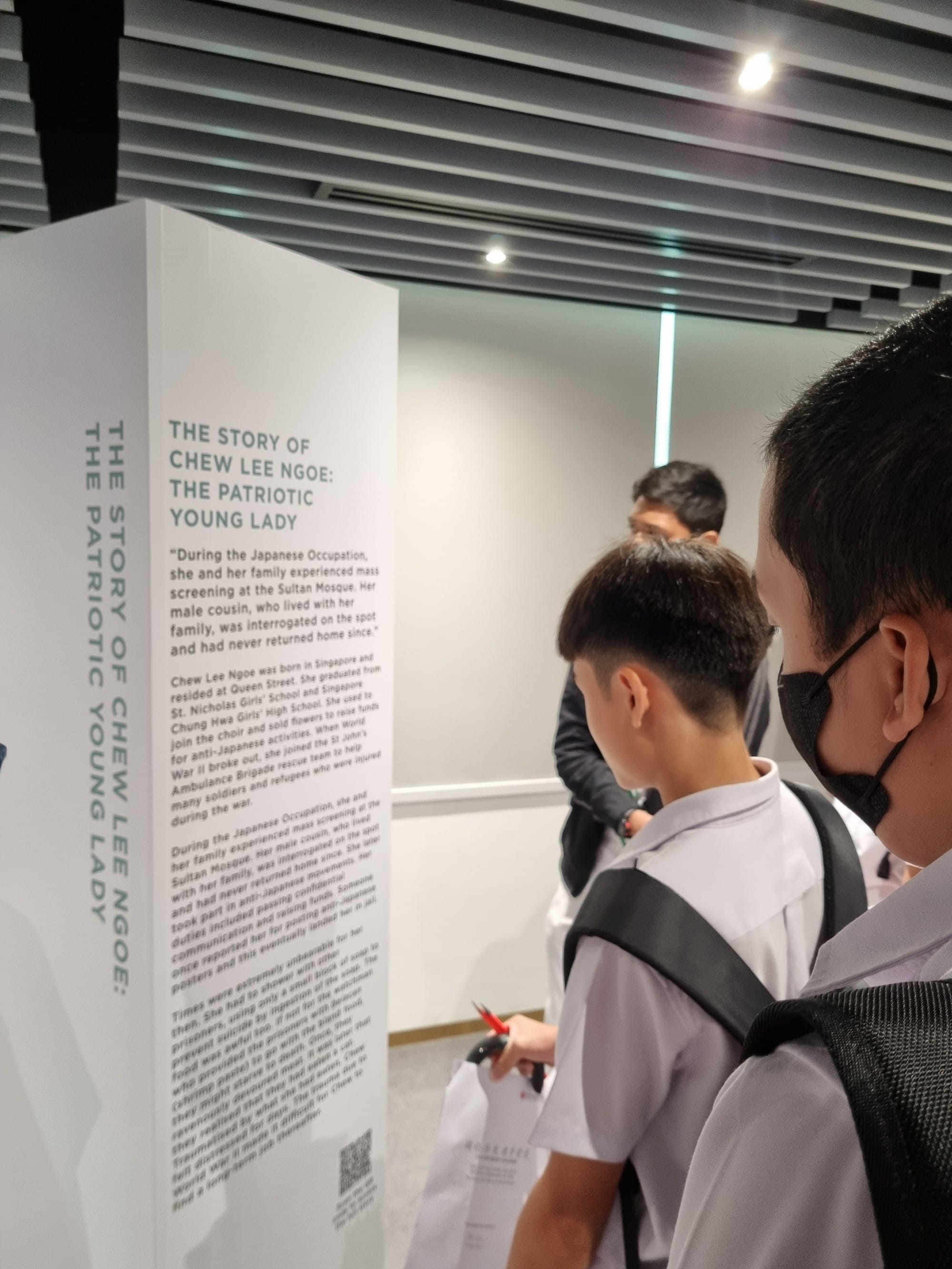 Students read an exhibition panel titled 'The Story of Chew Lee Ngoe: The Patriotic Young Lady' about the Japanese Occupation.